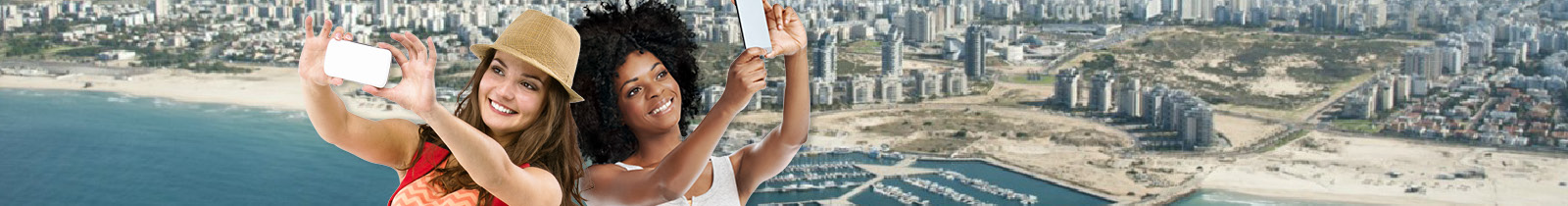 שתי בחורות עושות "סלפי" על רקע חוף הים של העיר